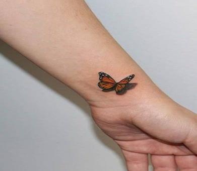 Realistic color monarch butterfly tattoo on thigh by Sorin Gabor TattooNOW